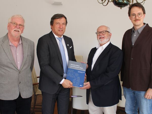 Dr. Marc Miltz (Landesamt für Denkmalpflege), Prof. Dr. Bernd Paeffgen (von rechts) sowie der Stadtheimatpfleger Archäologie Wilhelm Wagner (links) übergeben Oberbürgermeister Max Gotz das neue Buch mit Beiträgen über Erding.