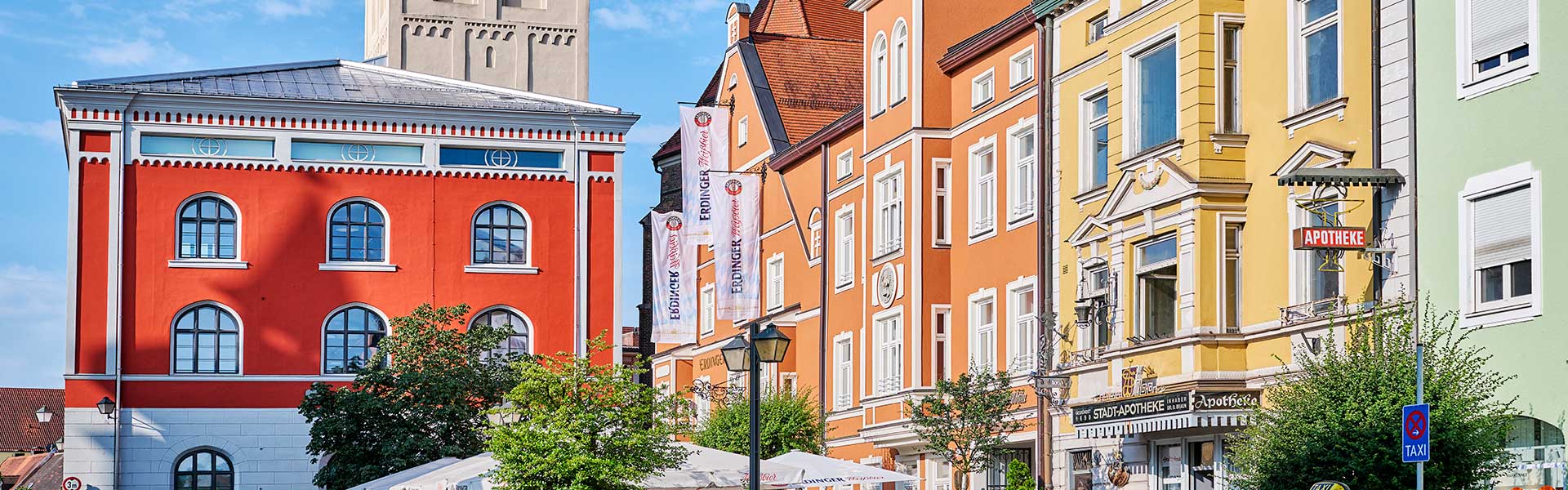 Bunte Häuserfassade der Langen Zeile mit dem roten Schrannengebäude im Hintergrund